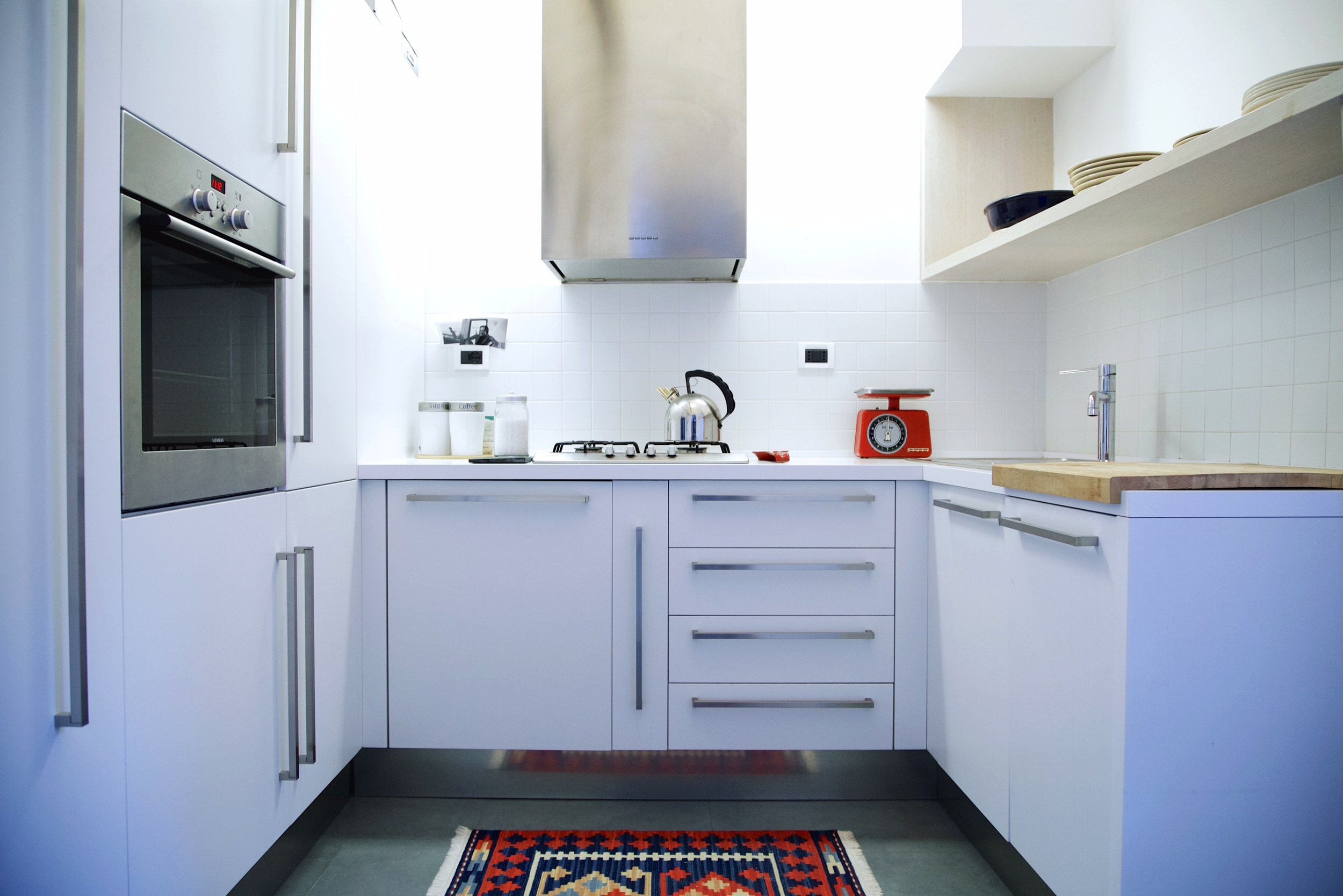 Cucina moderna con mobili bianchi e dettagli in acciaio