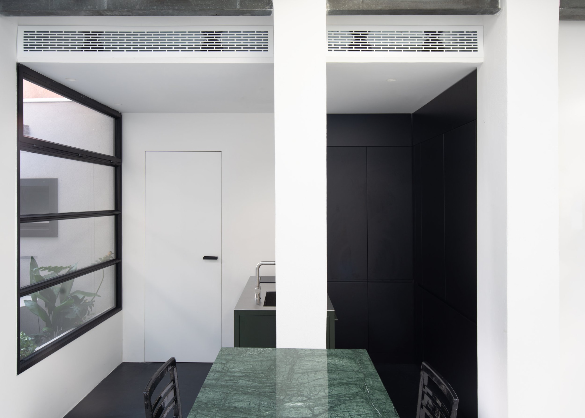 Loft a Venezia - Zona pranzo con tavolo verde e sedie nere