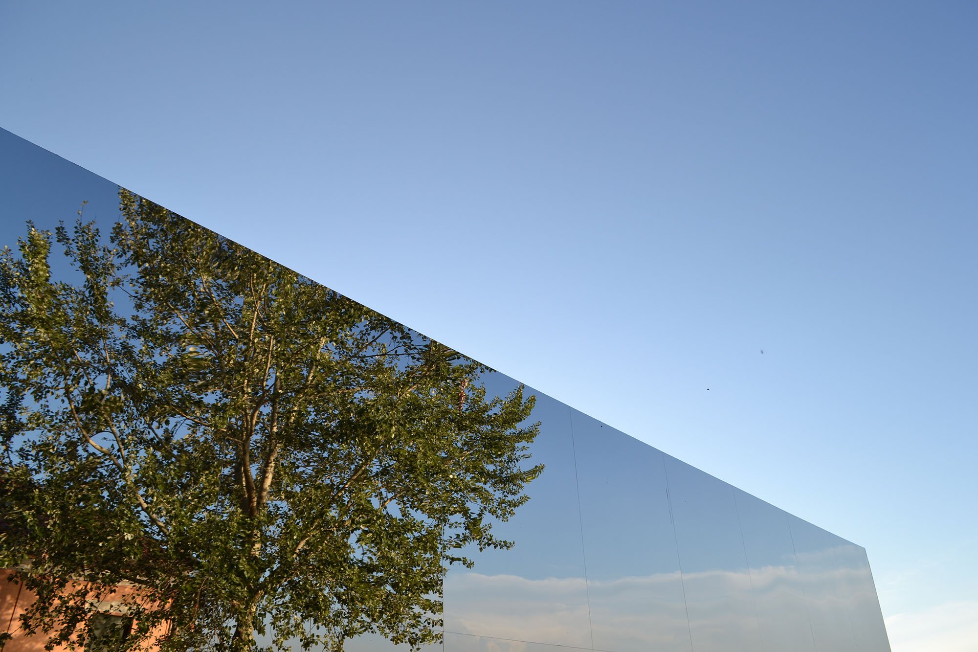 Barche e laguna riflessi su facciata specchiante