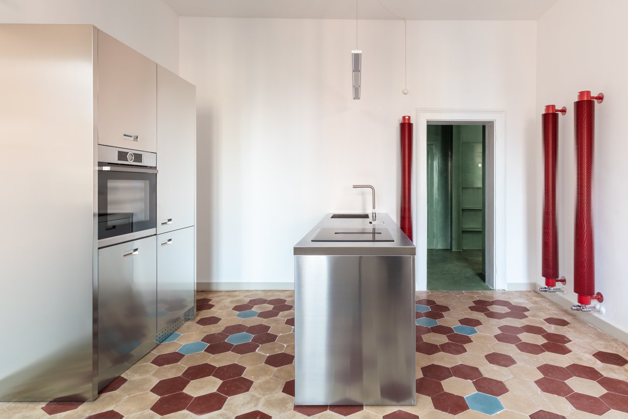 Cucina con isola in metallo e pavimento esagonale