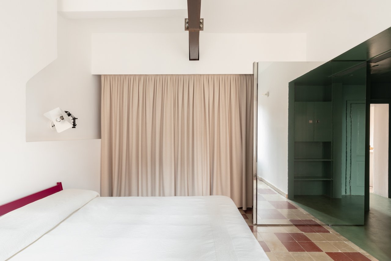 Camera con letto singolo e armadi verdi lucidi a specchio