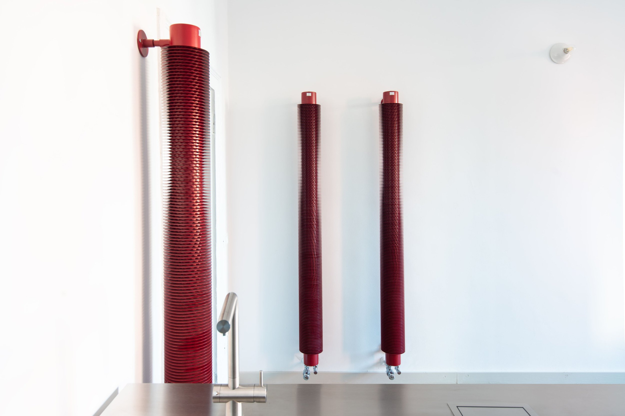Radiatori rossi a colonna verticale in metallo a vista